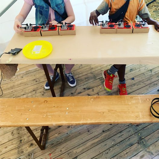 zwei Personen spielen an selbstgebauten DJ-Pulten